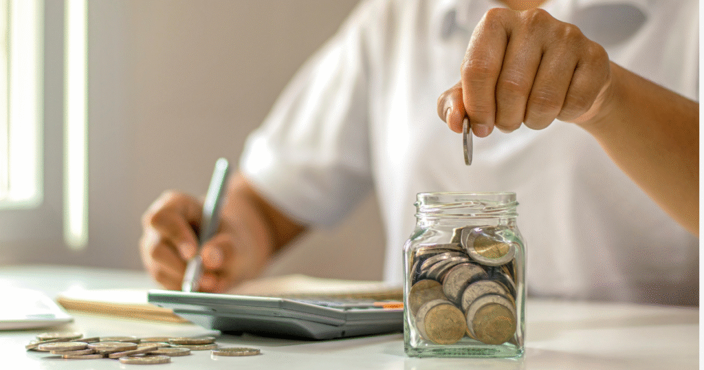 お金を数えながら家計簿をつけている男性