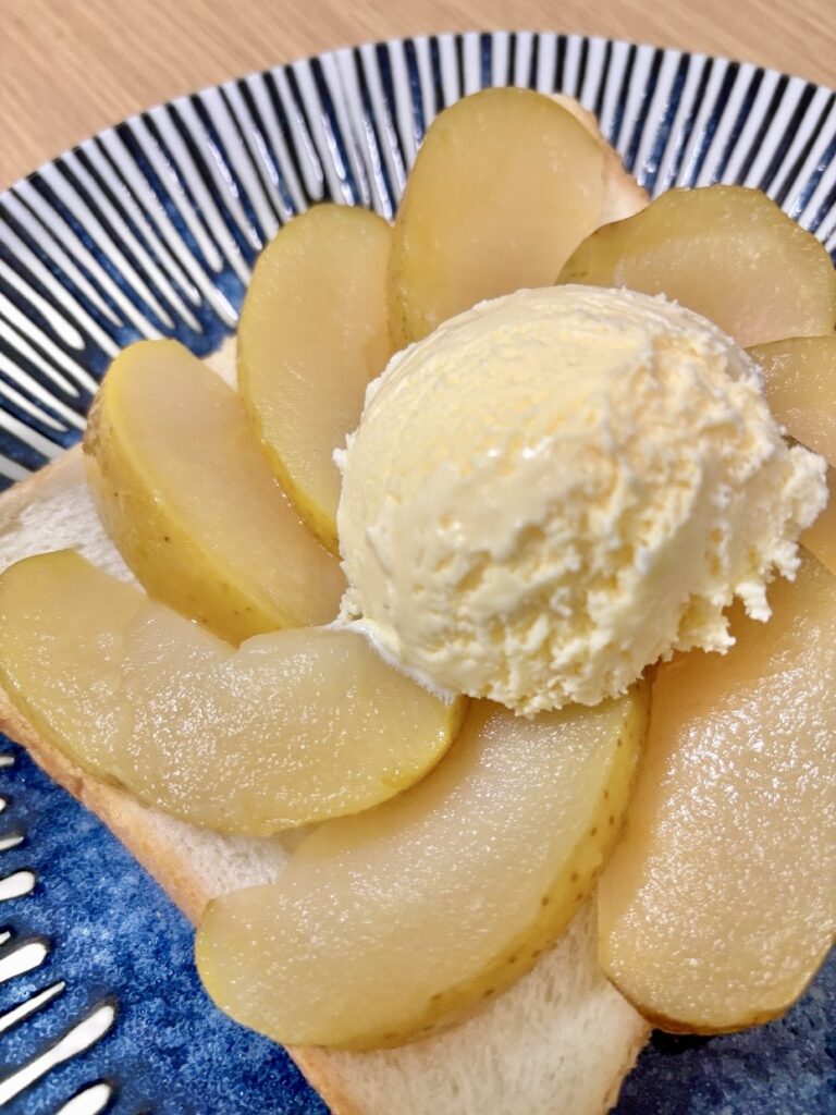 くし切りのリンゴのコンポートが花のように並べられており、中心にアイスが盛られている