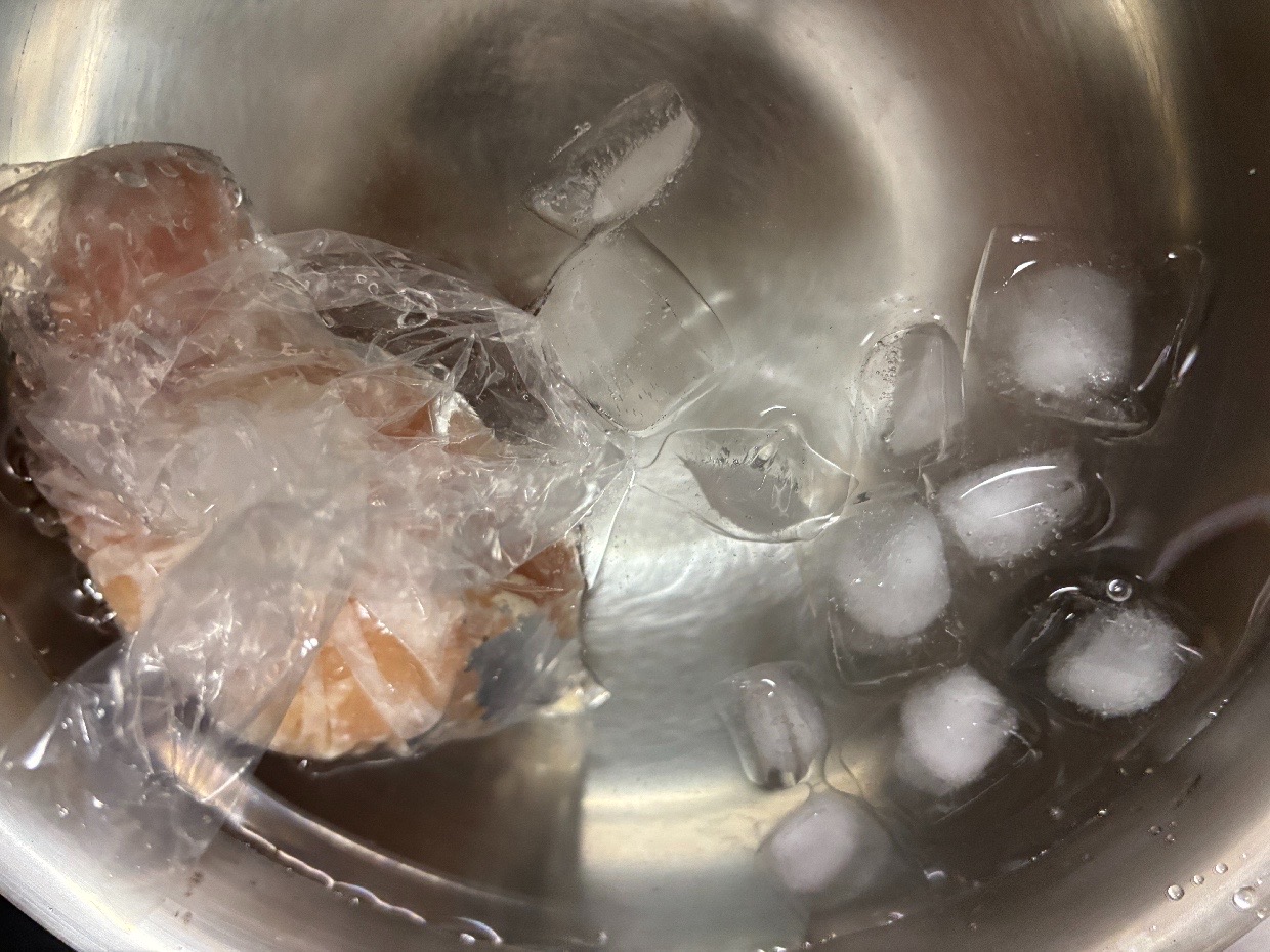 氷水を張ったボウルに袋のまま沈めた鶏むね肉
