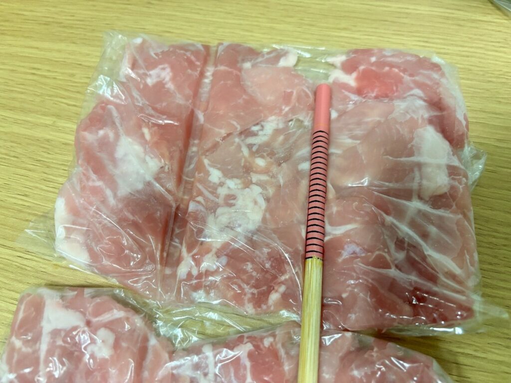 袋の上から菜箸を押し当てて線を付けているところ