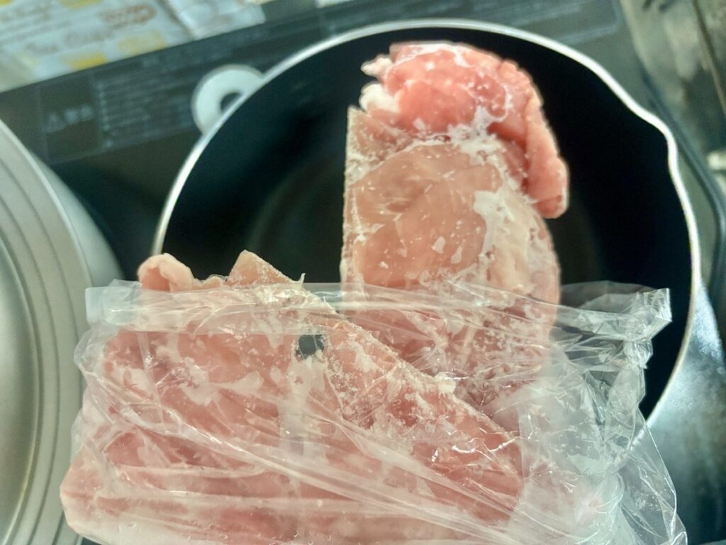 凍った豚こま切れを線のところで折って取り出しているところ