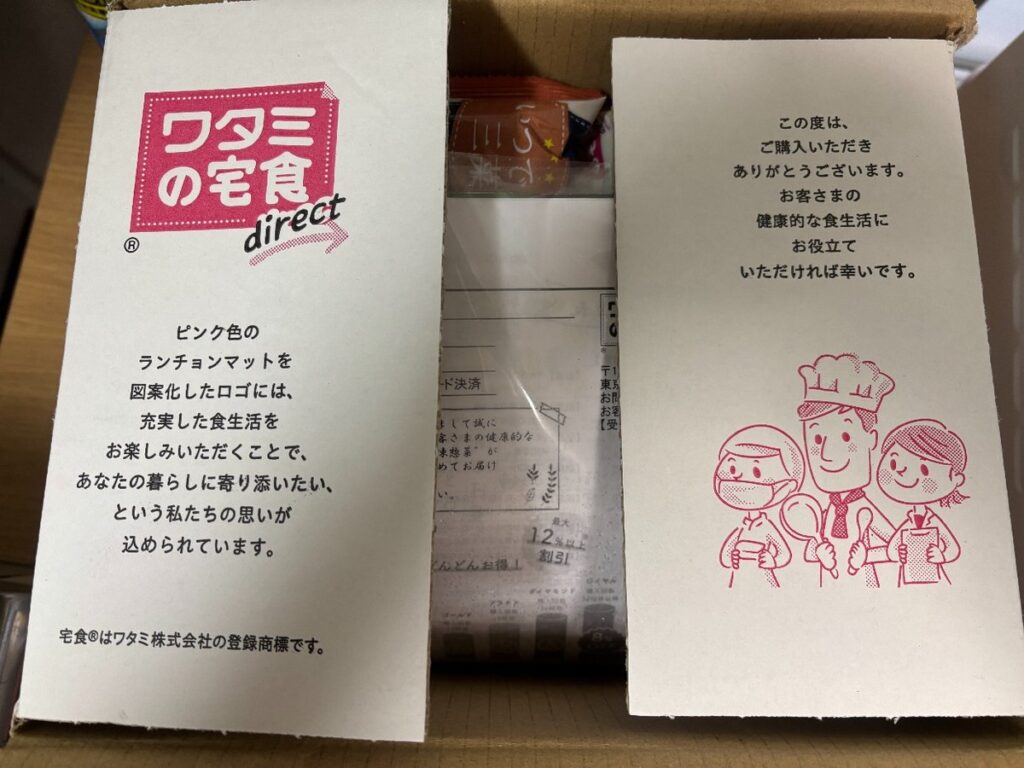 段ボールを開けたところ。あいさつカードの下に袋が入っている