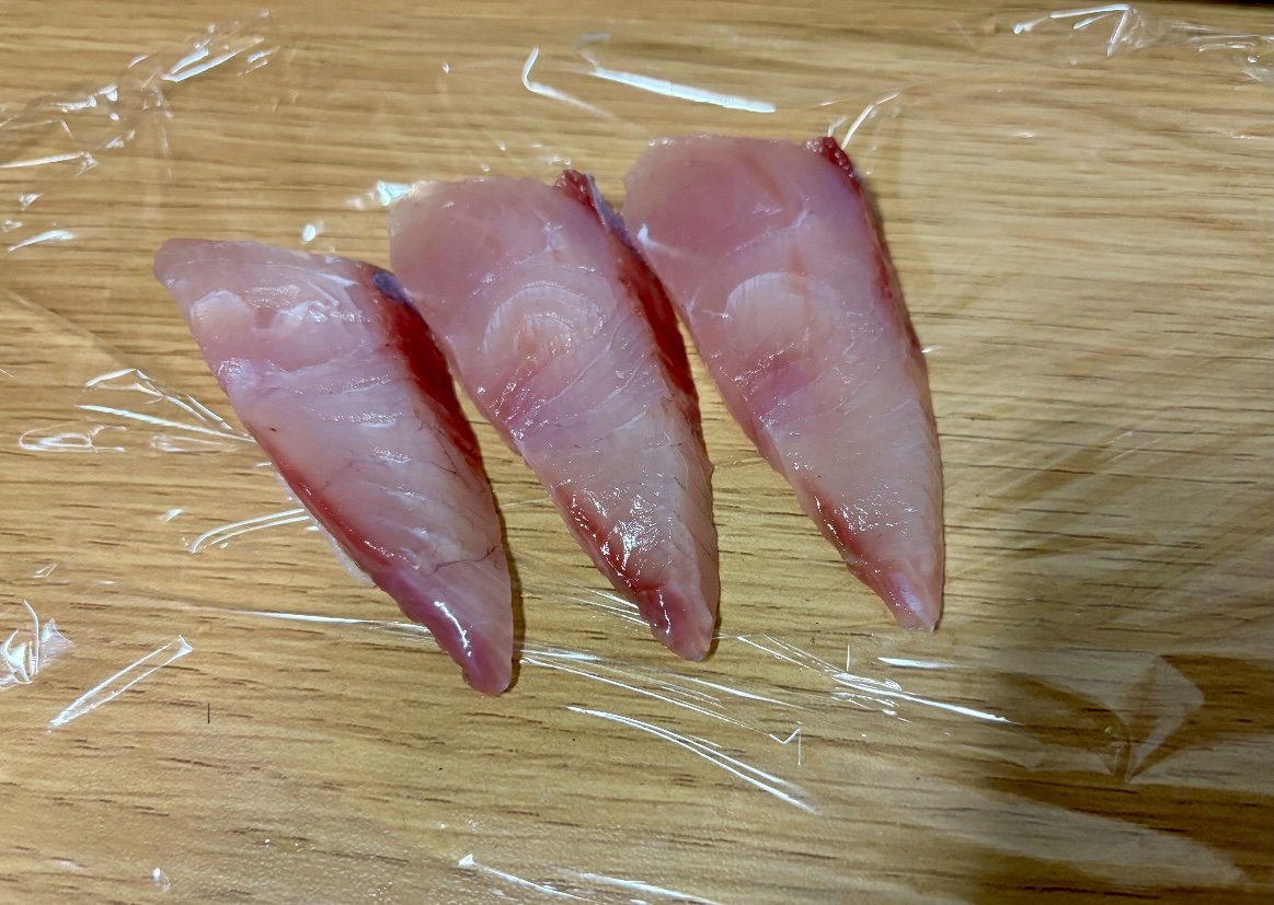 はまちの刺身3切れをラップの上に並べたところ