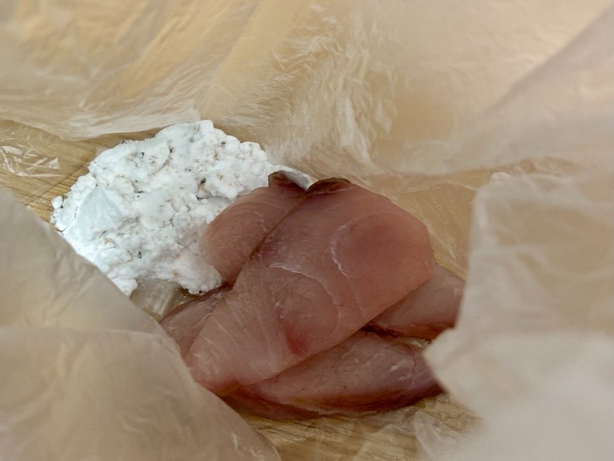袋の中で片栗粉をまぶしているはまちの切り身